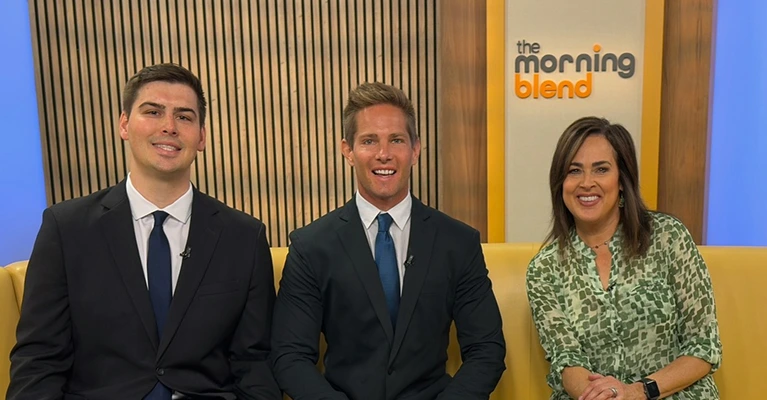 Axis Legal attorneys sitting with The Morning Blend TV hosts on a yellow sofa during a talk show segment.