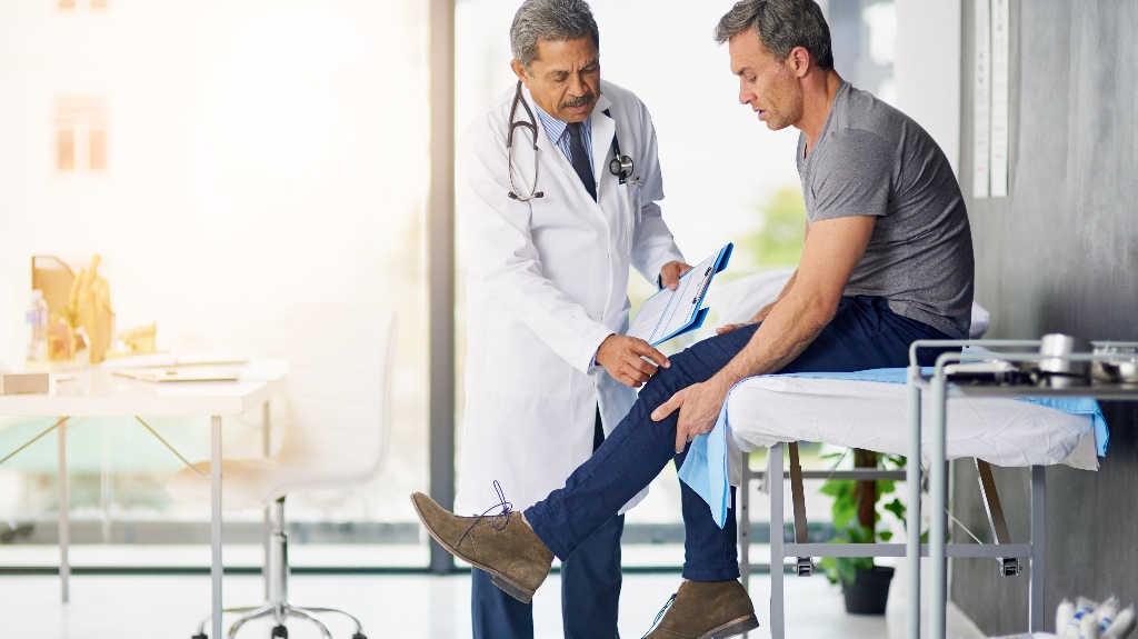 doctor examining his patient who is concerned about his knee