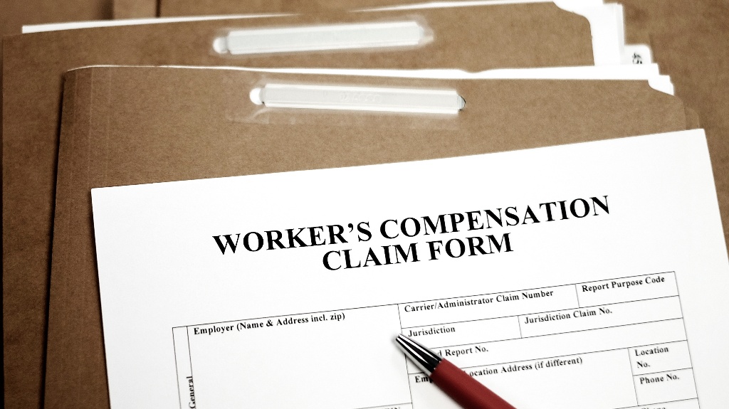 Workers Compensation Claim form and pen
