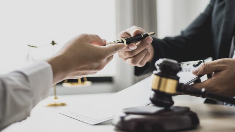 Attorney gives the client a pen to sign document