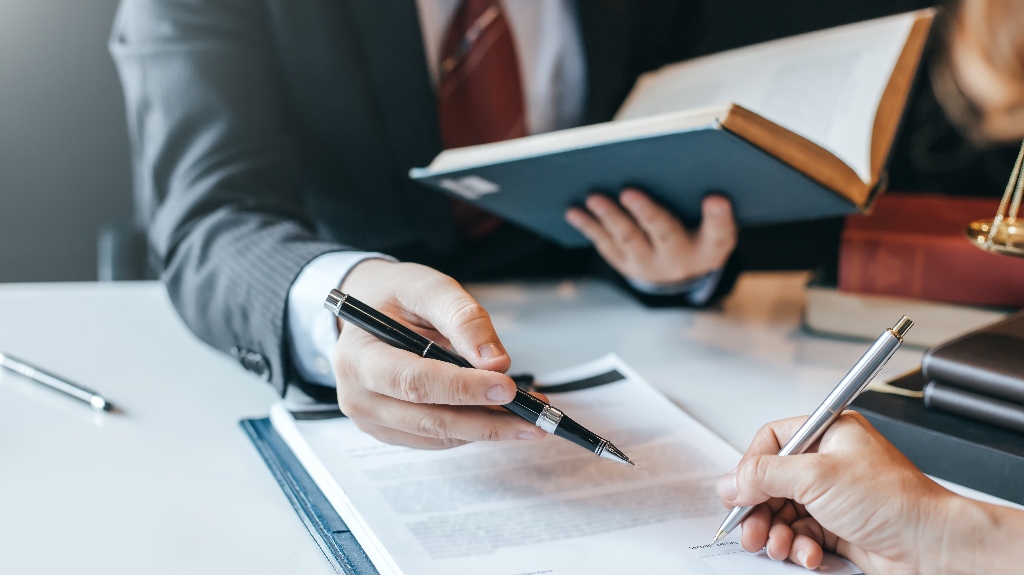 Lawyer is showing client where to sign document